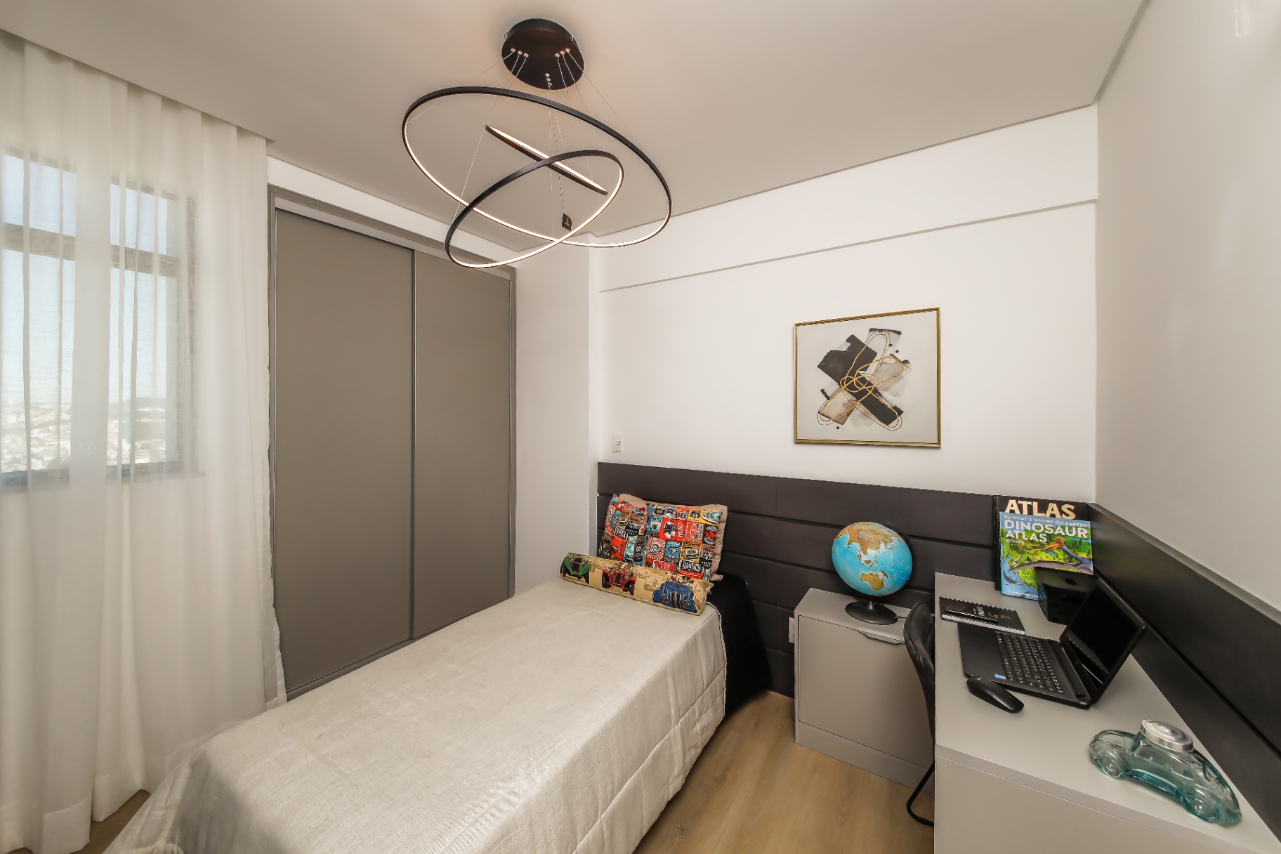 Quarto decorado com pendente escultural e escrivaninha integrada